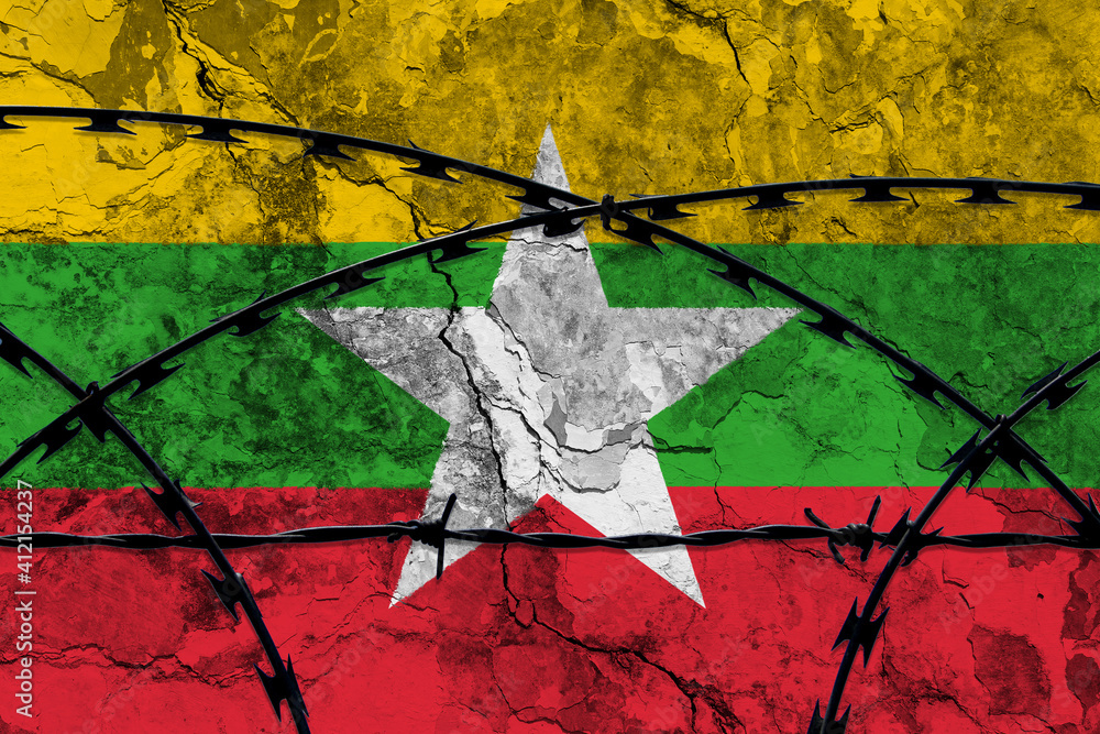 The national flag of Myanmar (Burma) painted on a grungy wall with Barbed wire in the foreground. Concept of the shut down in Myanmar after the military coup.