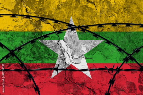 Obraz na płótnie The national flag of Myanmar (Burma) painted on a grungy wall with Barbed wire in the foreground. Concept of the shut down in Myanmar after the military coup. w salonie