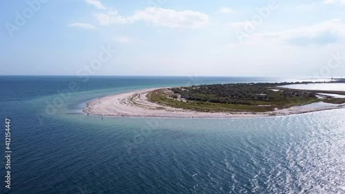 aerial view of the island with greenery in the middle of the blue sea
