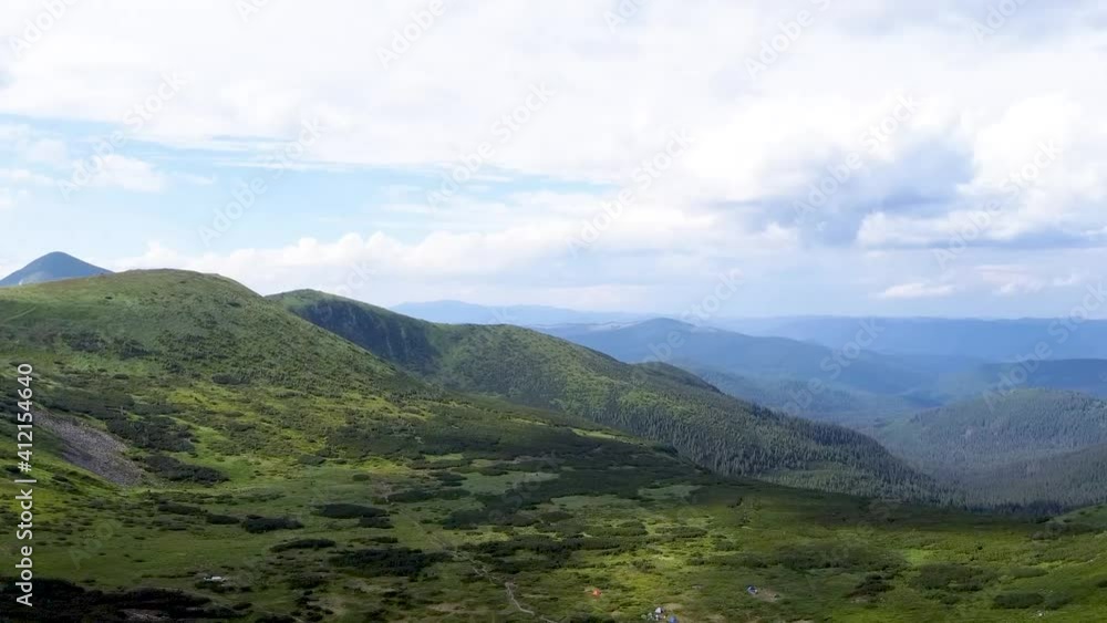 aerial view of green mountains with trees and valleys on a background of blue sky
aerial view of green mountains with trees and valleys on a background of blue sky