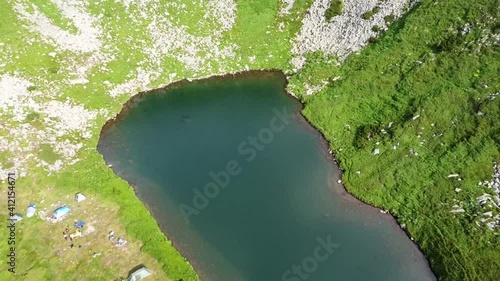 aerial view of green mountains with lake in the mountains with blue water
