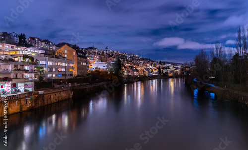 Blue hour in Z  rich  the largest city in Switzerland. Illuminated houses along the Limmat River and their reflections in the water