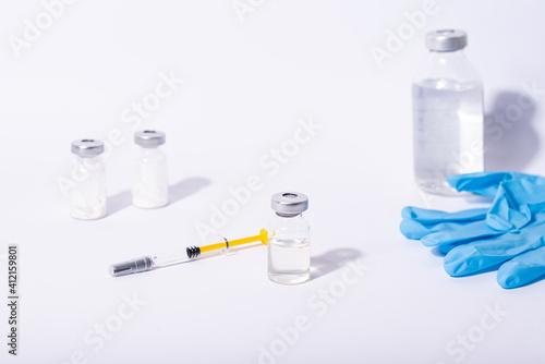 Coronavirus vaccine. Some ampoules and syringe with ncov-2019 vaccine in a box on blue background.