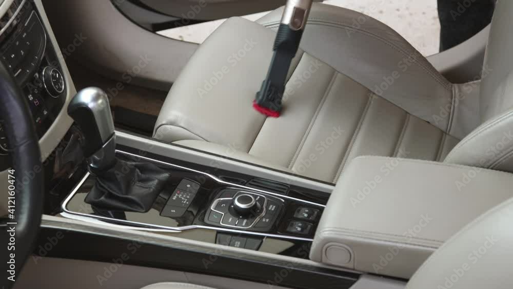 Professional car interior cleaning. Vacuuming leather seats. Dust and dirt removal Professional car interior cleaning. Vacuuming leather seats. Dust and dirt removal