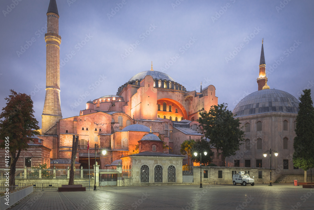 Naklejka premium A twilight view from Sultanahmet Park in Istanbul, Turkey of the iconic Hagia Sophia, once a Byzantine Church converted to a mosque by the Ottomans, illuminated at night.