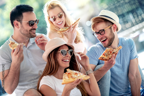 Group of young people eating pizza