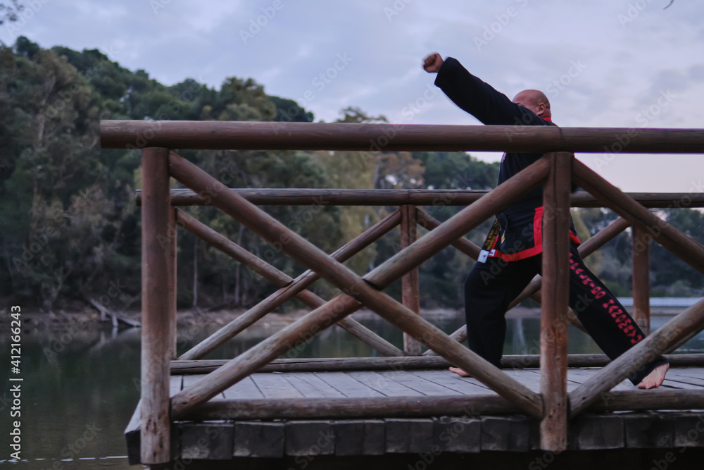 man practicing sipalkido discipline outdoors in a lake in a sunny day man practicing sipalkido discipline outdoors in a lake in a sunny day