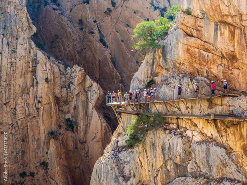 Obraz na płótnie Excursionistas andando por un desfiladero entre montañas en el Caminito del Rey