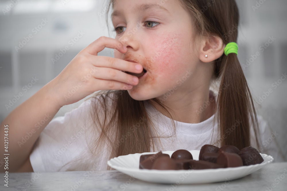A little girl with an allergic rash on her cheeks sits at a table next