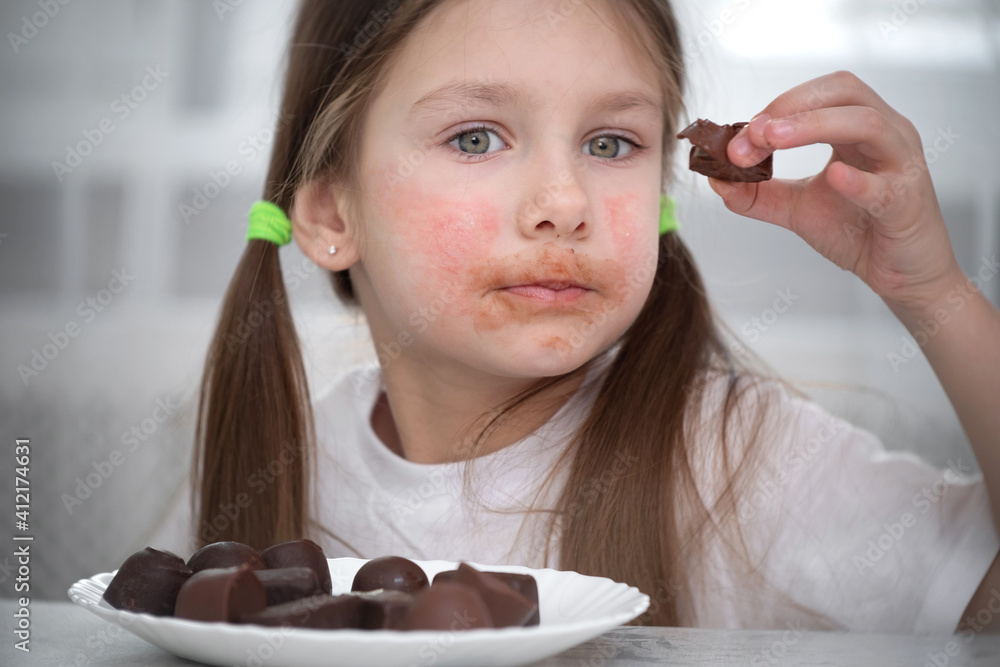 A little girl with an allergic rash on her cheeks sits at a table next