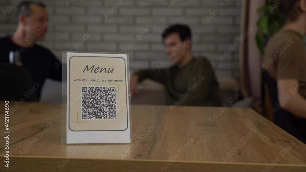 QR display with contactless digital menu on the table in the restaurant or bar. QR Ordering using QR code scanning app. Fight COVID-19