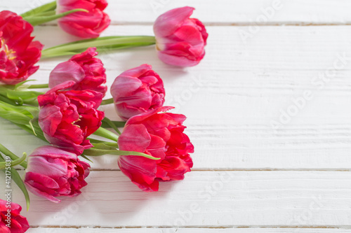 red tulips on white wooden background