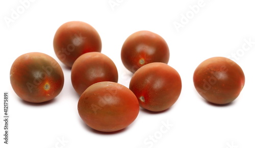 Mini kumato tomato pile isolated on white background