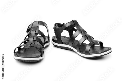 Black female sandals on white background isolated closeup front view, stylish woman sandal shoes with straps, pair of fashion leather summer sandals, two boots, casual walking footwear, urban footgear