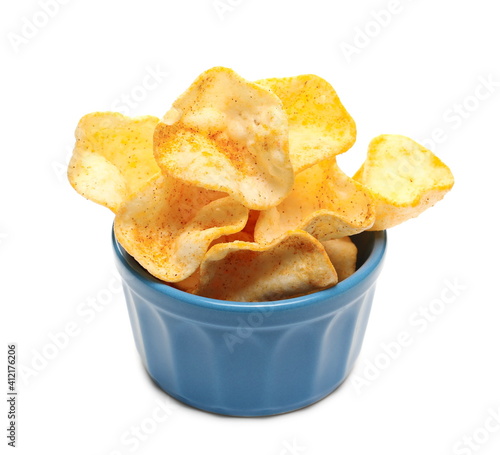 Potato chips with paprika flavor in porcelain bowl, pepper powder crisps isolated on white background
