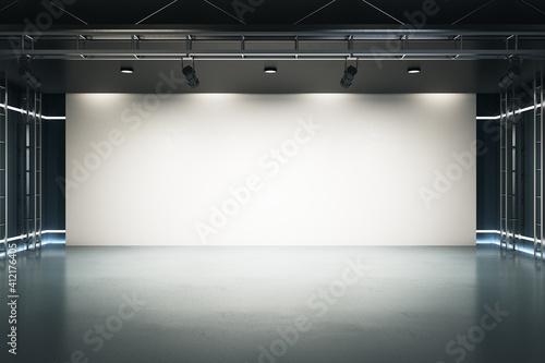 Big blank light screen instead of wall with projectors in empty industrial style hall room with glossy floor. Mockup. 3D rendering.