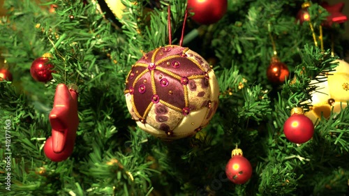 Christmas tree decoration. Woman hanging ball on Christmas tree. Kimekomi ball.
 photo