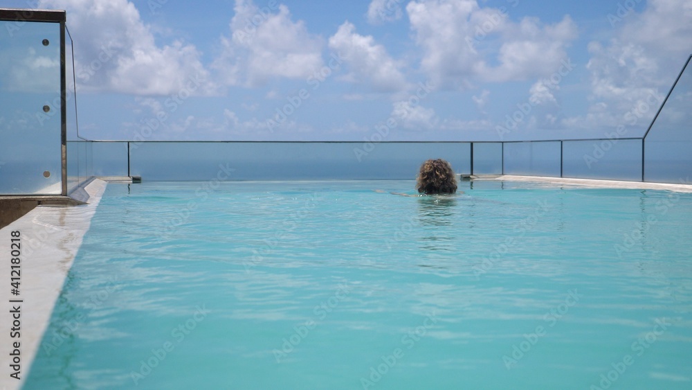 Obraz premium Luxury vacations at the hotel with the infinity swimming pool overlooking an ocean