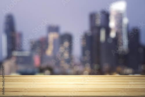 Empty table top made of wooden dies with blurry city view at dusk on background  template