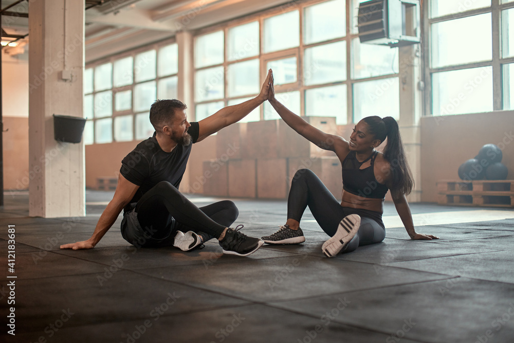 Fototapeta premium Workout partners high-fiving at the gym