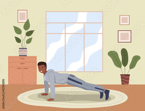 Home exercise. Young man in sports wear doing push-ups at home. How to keep fit indoors. Fitness and morning workout in cozy interior. Healthy lifestyle and wellness concept. Gymnastics practice
