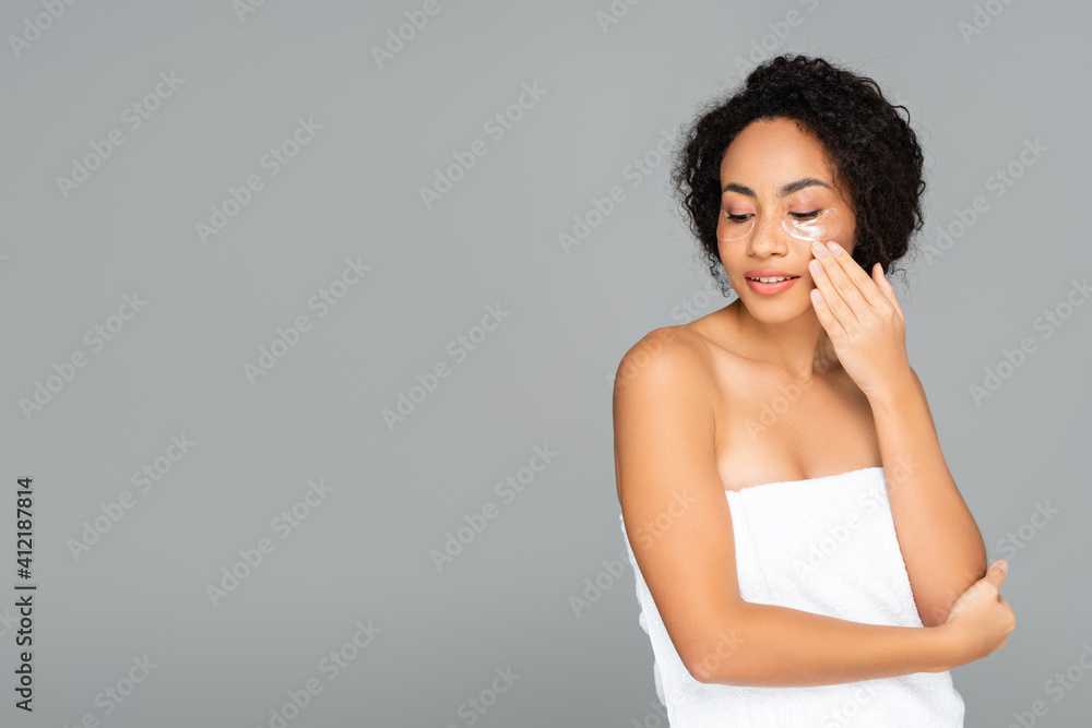 African american woman in towel and eye patches isolated on grey African american woman in towel and eye patches isolated on grey