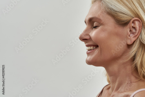 Billede på lærred Happy middle aged woman laughing with closed eyes