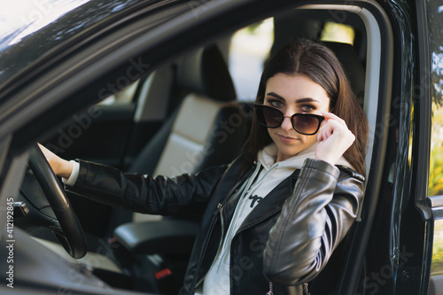 Young beautiful girl Takes off 
 sunglasses  in the car.
