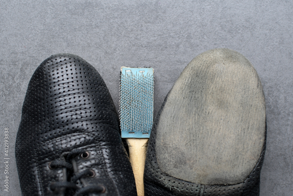 Wooden shoebrush next to ballroom dancing shoes. Use a brush to loosen