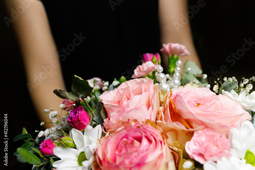Defocus Gift box with flowers. Close up of box with pink roses in female hands. Female receive gift for mother s day  valentines  women day  birthday. Out of focus
