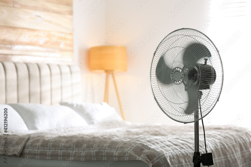 Modern electric fan in bedroom. Space for text - obrazy, fototapety, plakaty 