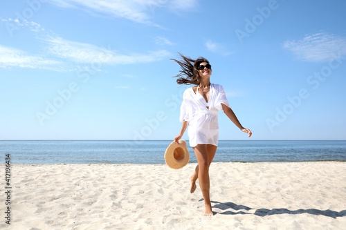 Young woman with beautiful body on sandy beach. Space for text