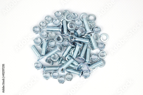 A pile of screws, nuts and washers folded in the center of the image