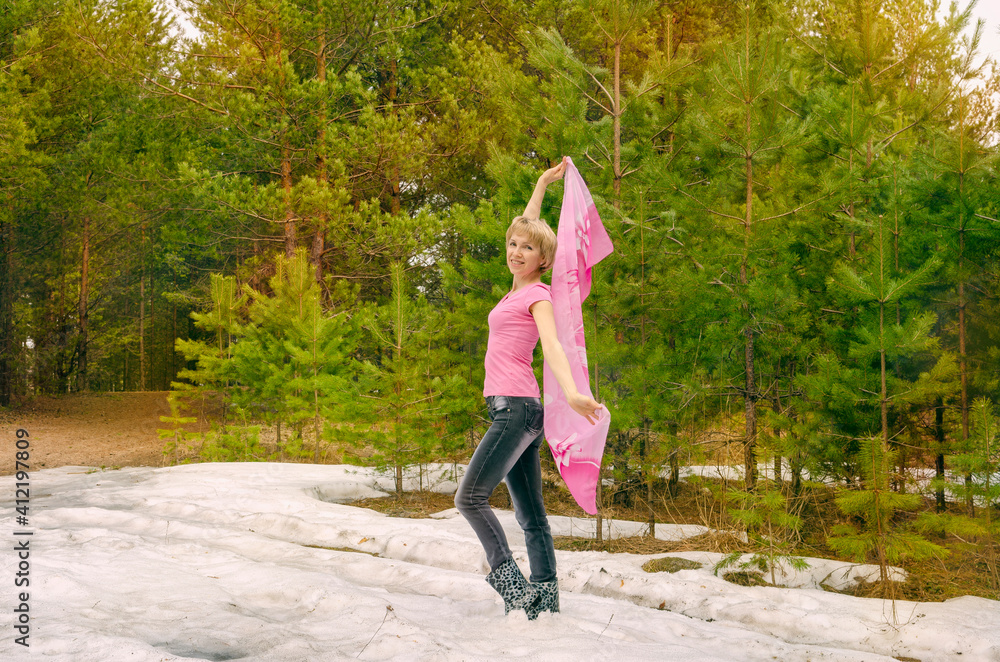 The woman rejoices the spring in the woods on the remnants of snow. The woman rejoices the spring in the woods on the remnants of snow.