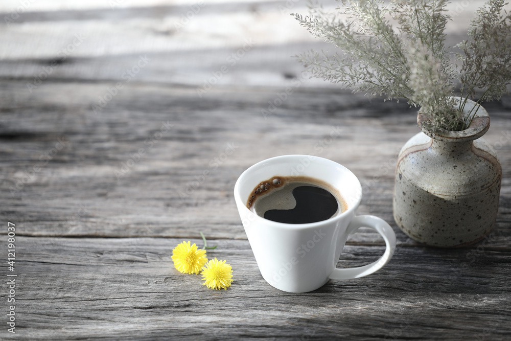 small white coffee cup and and flowers on grey wooden table small white coffee cup and and flowers on grey wooden table