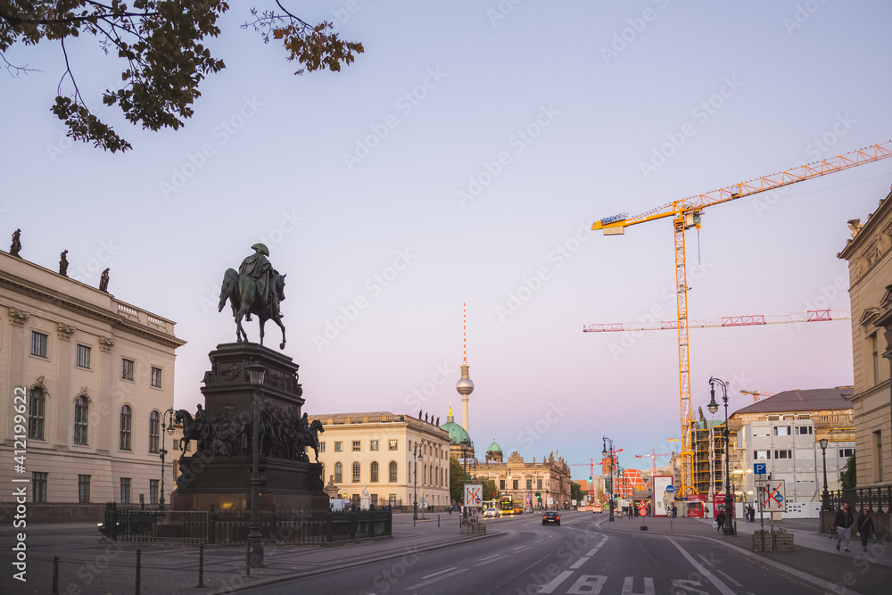 Sunset or sunrise cityscape view of the Equestrian statue of Frederick the Great along Unter den Linden leading to the Berliner Dom and tv tower in Berlin, Germany.
