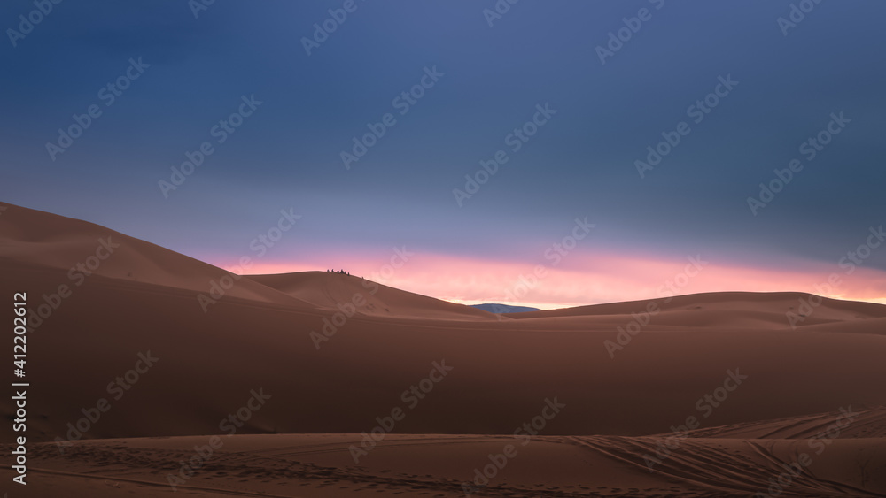A moody sunrise or sunset landscape view of the desert sand dunes of Erg Chebbi near the village of Merzouga, Morocco.