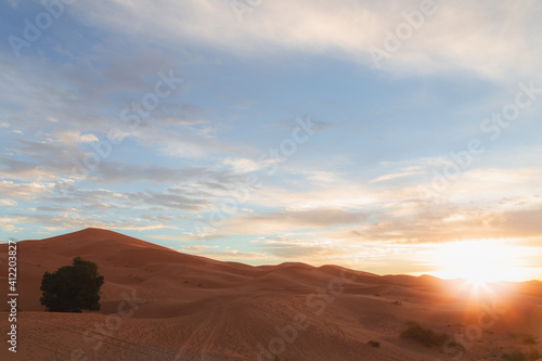 A sunrise or sunset landscape view of the desert sand dunes of Erg Chebbi near the village of Merzouga, Morocco.