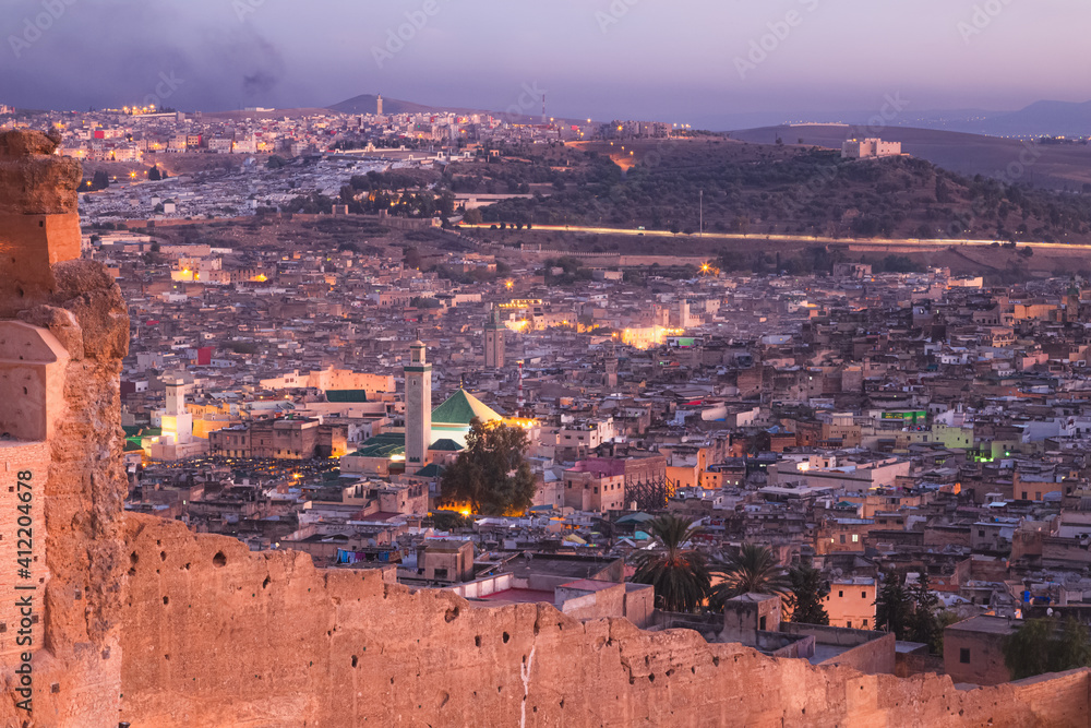 Night cityscape skyline view of the old town and fortified city walls of Fez, Morocco, the country's second largest city renowned for its historic Fes el Bali walled medina.
