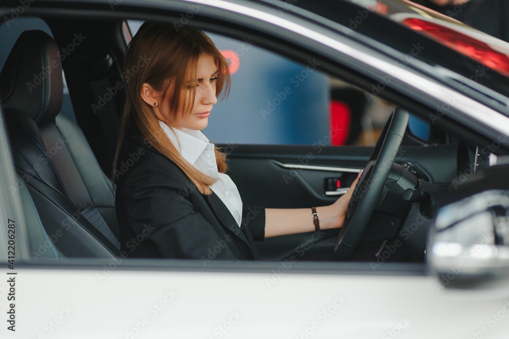 Photo of happy young woman sitting inside her new car. Concept for car rental Photo of happy young woman sitting inside her new car. Concept for car rental
