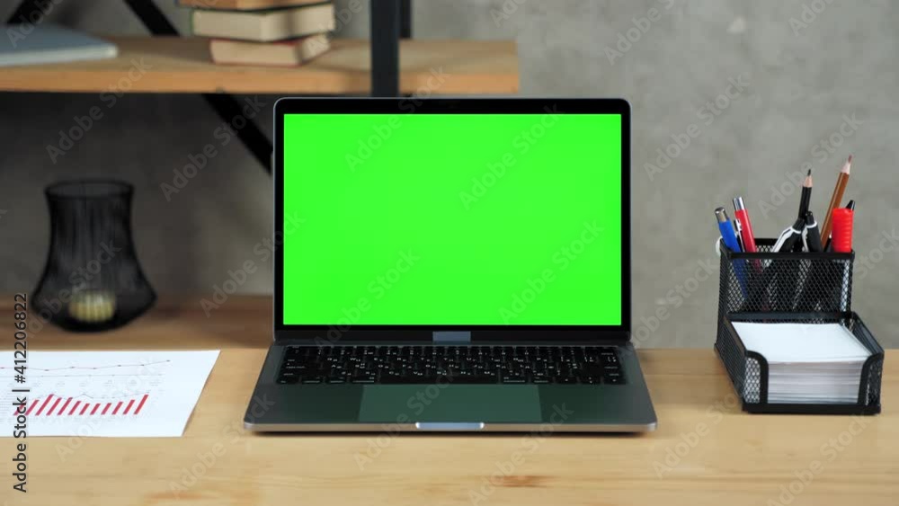 Modern laptop computer display with mock up chroma key green screen standing on table working office business workplace Modern laptop computer display with mock up chroma key green screen standing on table working office business workplace