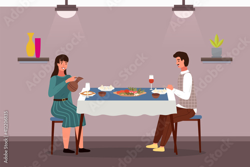 People at lunch in Georgian style. Couple on a date in a theme restaurant eats khinkali and adjarian khachapuri. Man and woman communicating at dining table. Georgians taste traditional food