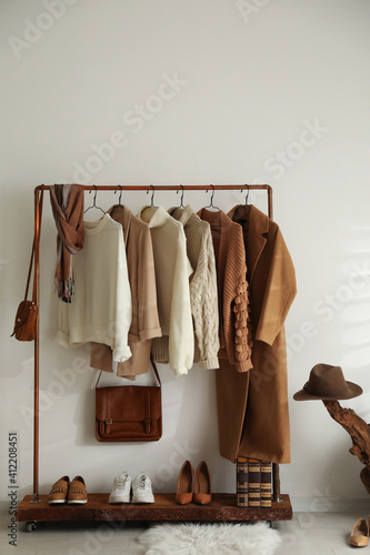 Modern dressing room interior with rack of stylish shoes and women's clothes photo