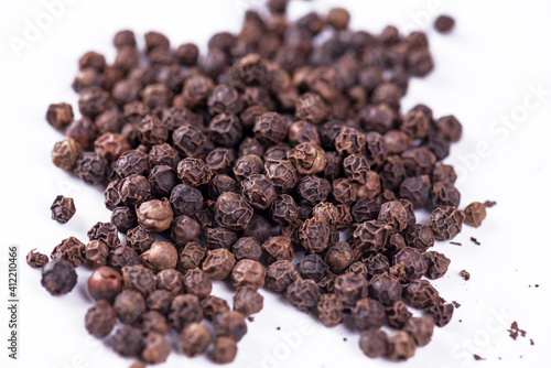 Black pepper. Heap of peppercorns isolated on white background.