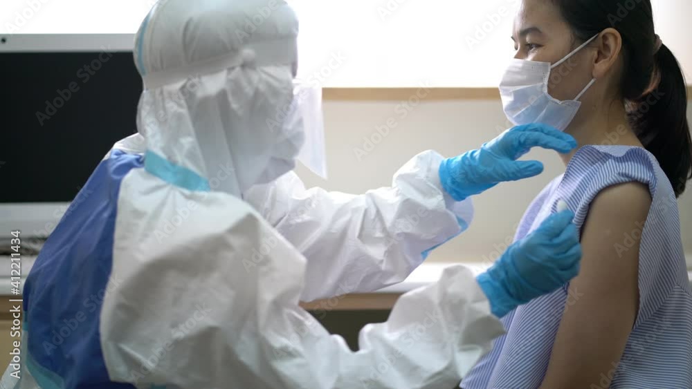 video of Asian doctor or nurse wearing ppe suit and face mask in hospital with an injection vaccine for covid-19 or corona virus patient. Corona virus, Covid-19, virus outbreak or medical mask concept video of Asian doctor or nurse wearing ppe suit and face mask in hospital with an injection vaccine for covid-19 or corona virus patient. Corona virus, Covid-19, virus outbreak or medical mask concept