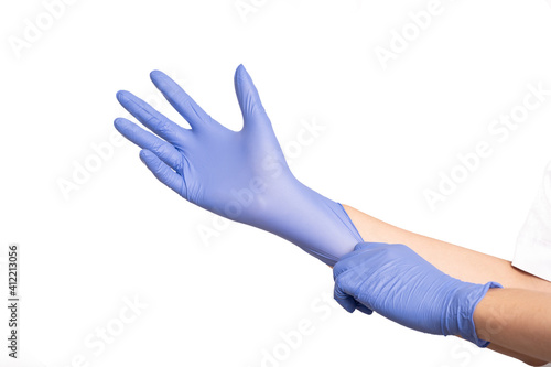 Man's hands wearing violet latex gloves by pulling another side for perfect fit, isolated on white background