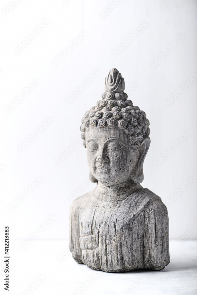 Meditating Buddha Statue on bright wooden background. Copy space.