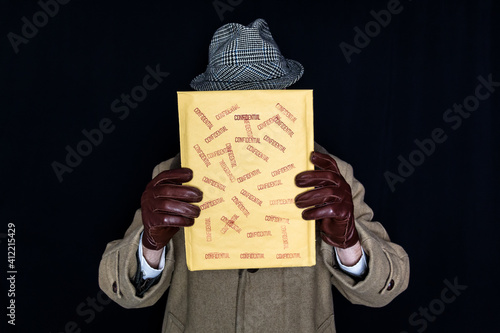 Portrait of Man in Hat and Coat Holding Confidential Envelope. Concept of Film Noir Secret Agent Spy Hero. Detective on Case. Theft and Crime. photo