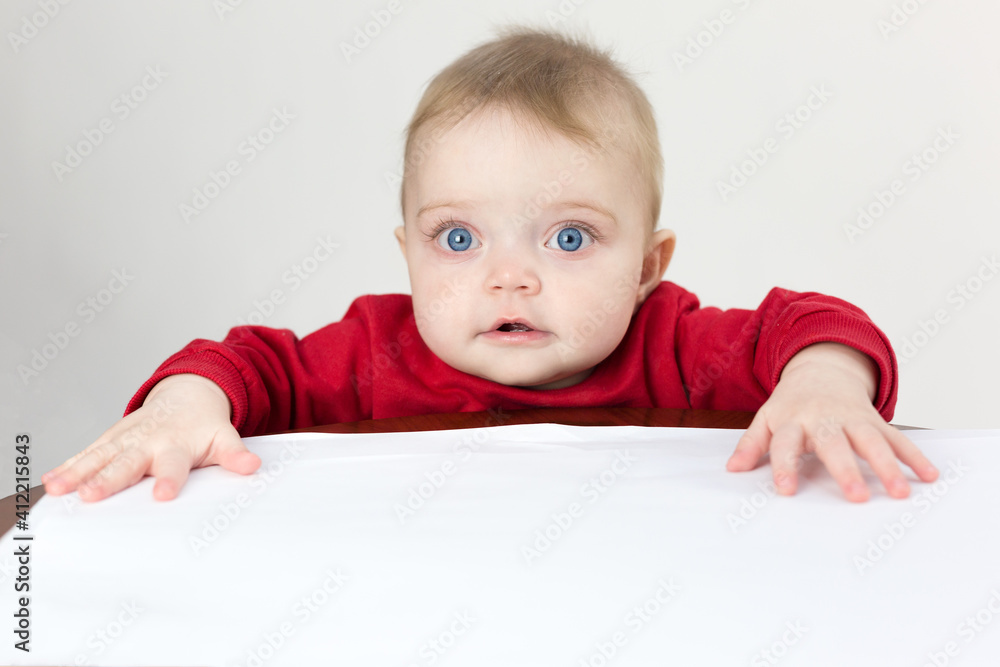 The child holds white sheets of paper in his hands. The child holds white sheets of paper in his hands.