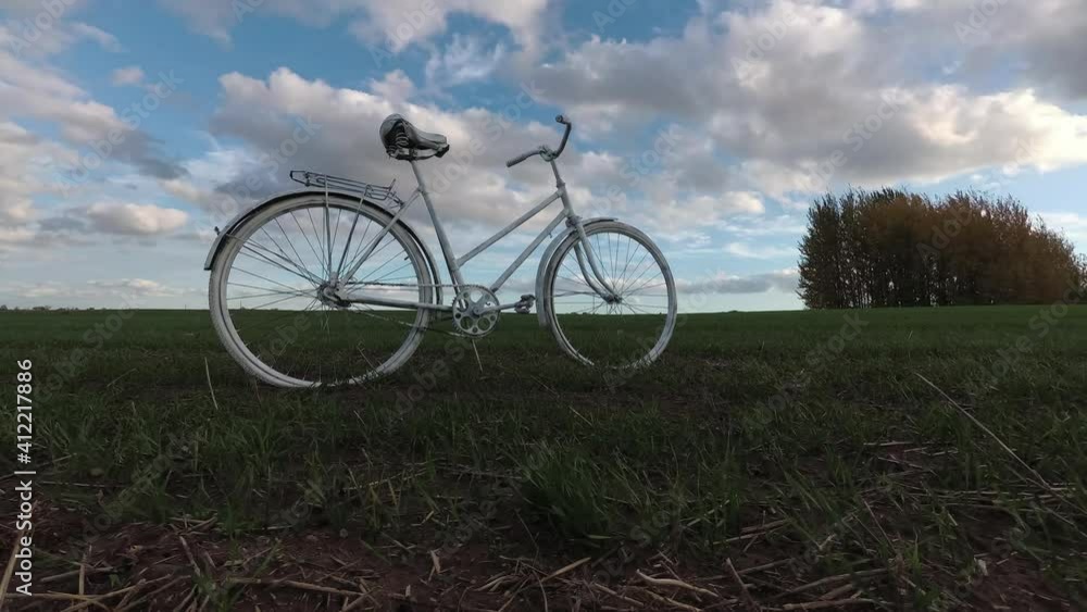 Old white bicycle on field and clouds motions, time lapse Old white bicycle on field and clouds motions, time lapse